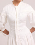 White shirt dress with shaped seams, full skirt, and lace-up back