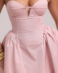 Blush pink mini dress with defined bust, cinched waist, and exaggerated silhouette